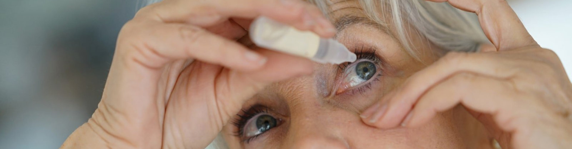 senior applying medicine on eyes