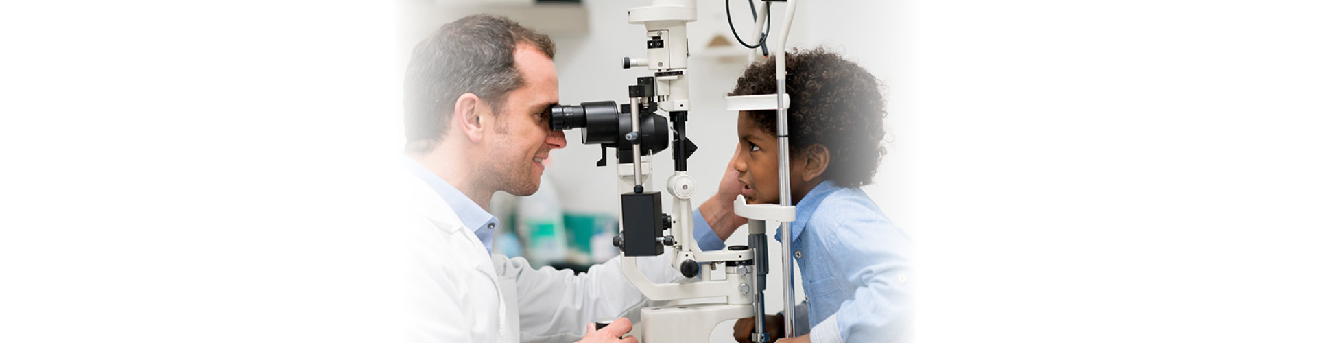 doctor checks vision of a child boy
